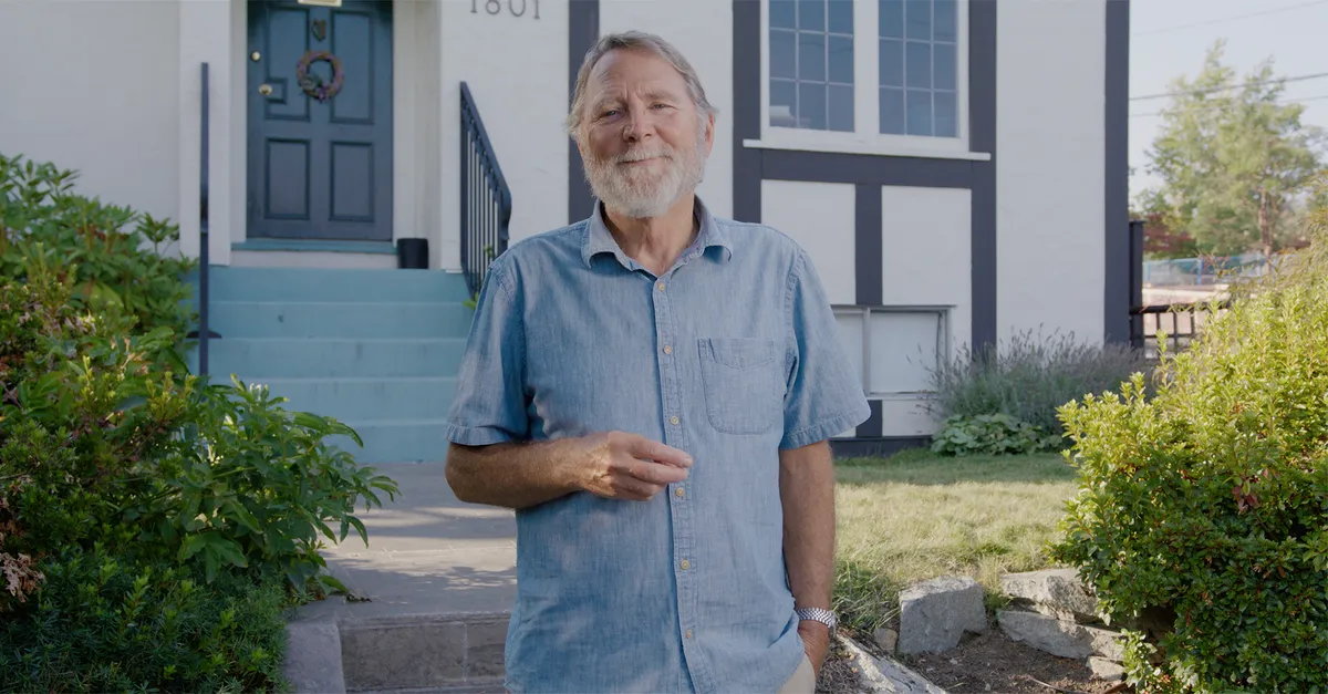 Documentary production portrait — older man smiling outside his home